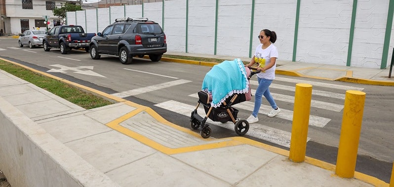 persona con una coche de bebé cruzando pista
