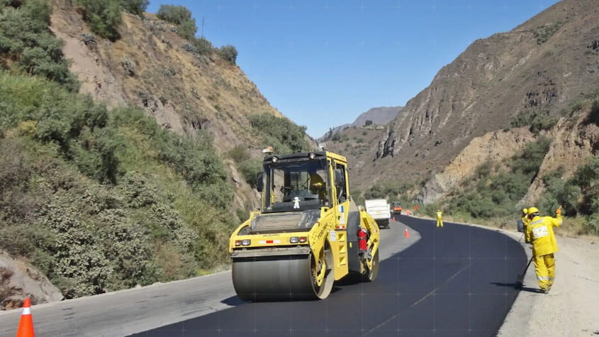 Maquinaria pesada realiza asfaltado en carretera andina como parte de obras viales en regiones, mejorando la conectividad y el transporte.