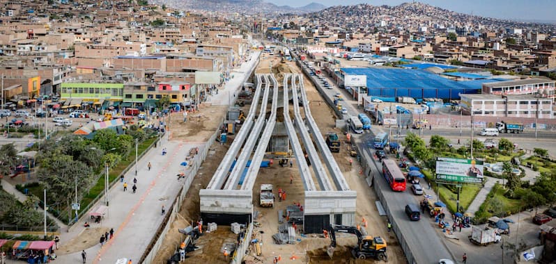 Avance de la construcción del viaducto de la Línea 2 del Metro de Lima, con maquinaria pesada y estructuras elevadas en zona urbana.