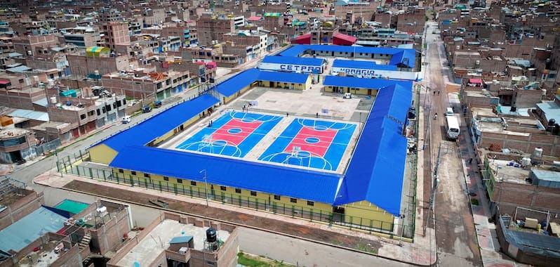 Vista aérea del CETPRO Mariano Melgar en Puno, moderna infraestructura educativa con techos azules y canchas deportivas integradas.