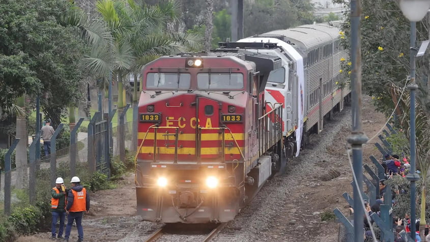 Tren de pasajeros Lima–Chosica en marcha, con técnicos en vía férrea y público observando, mejora ferroviaria