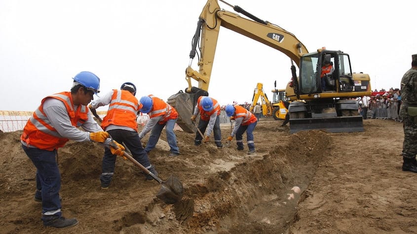 Obreros y excavadora abren zanja en obra de infraestructura vial, proyecto ejecutado en modalidad gobierno a gobierno